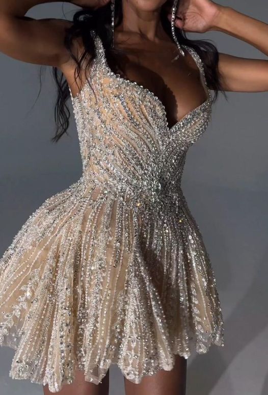 Detail of the wide beaded straps and sweetheart neckline of the silver dress.