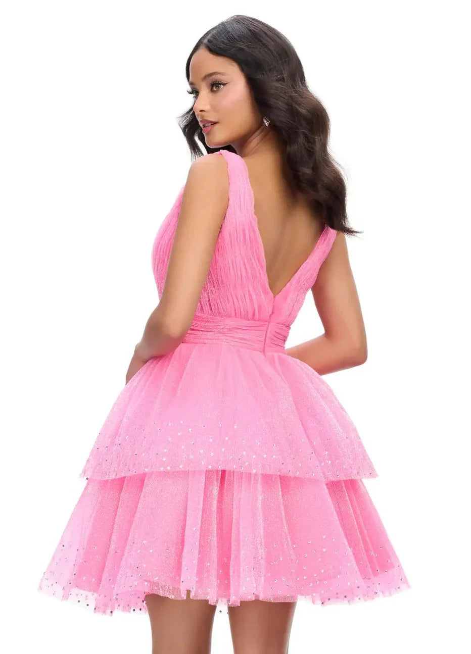 Model wearing a hot pink V-neck sleeveless glitter tulle tiered mini homecoming dress.