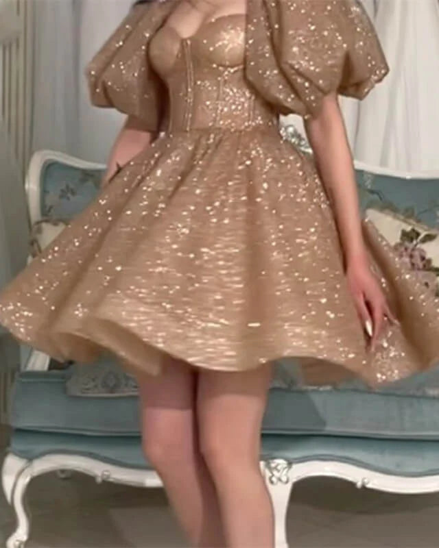 Close-up of the sparkling gold fabric and short sleeves on the A-line homecoming dress.