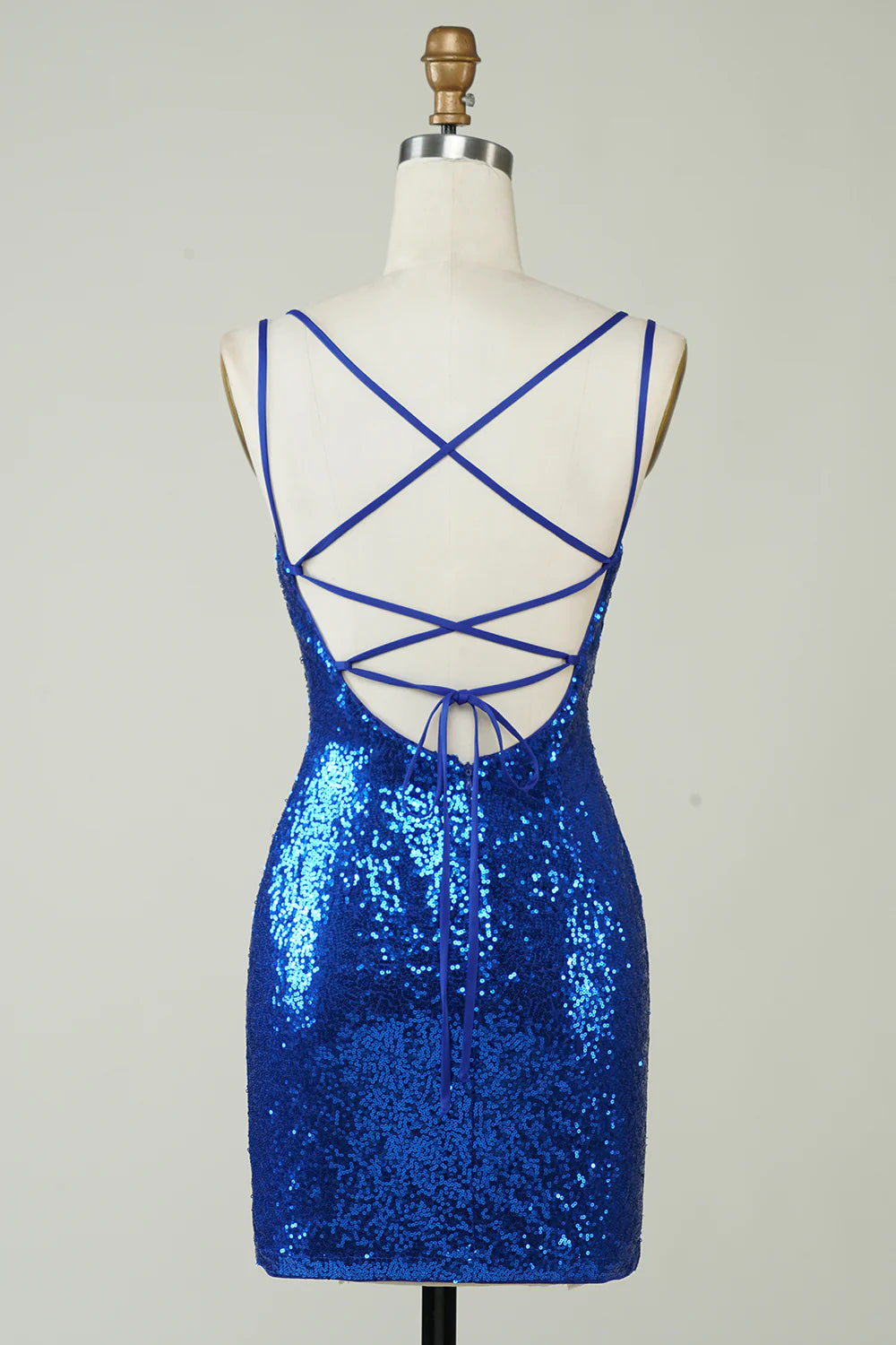 Side view of a model in a royal blue sequin backless mini dress.