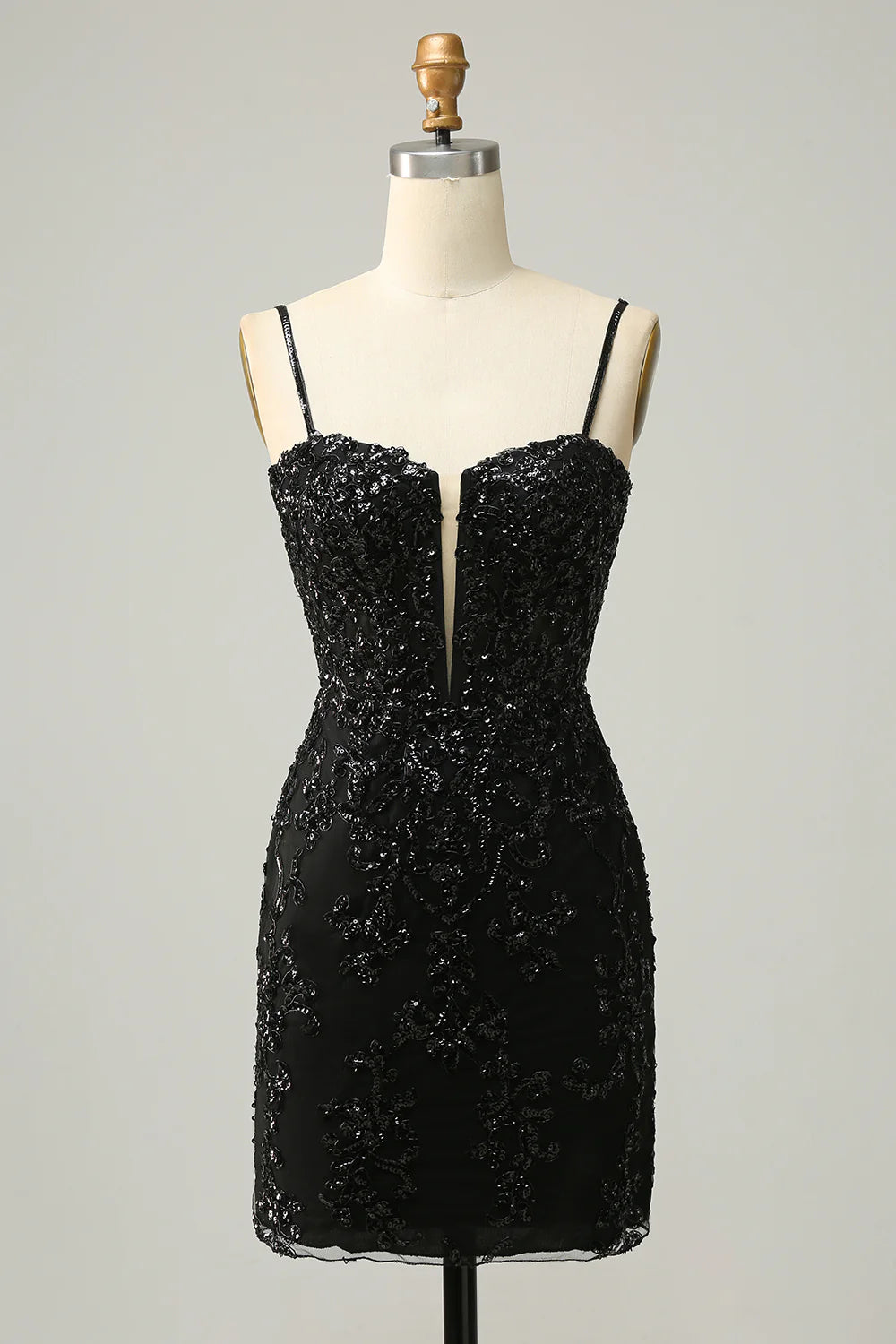 Model wearing a sparkling black sheath homecoming dress with V-neck and criss-cross back.