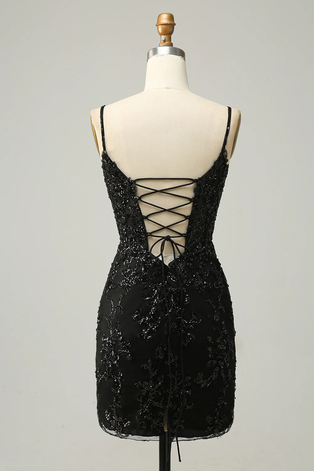 Back view of a black sequined sheath dress with criss-cross straps.