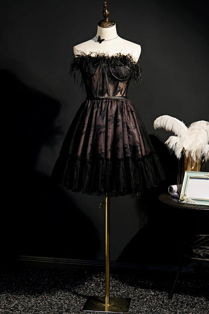 Model wearing a black strapless A-line tulle short homecoming dress.