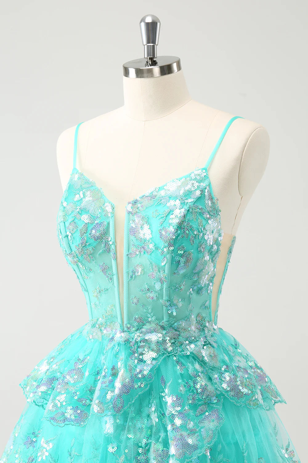 Model posing gracefully in the dazzling green A-line homecoming gown.
