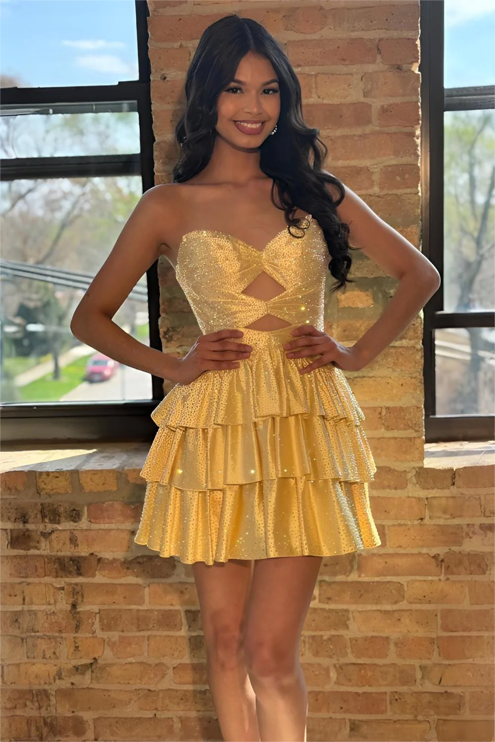 Shiny yellow strapless homecoming dress with a front cutout and tiered ruffle skirt.