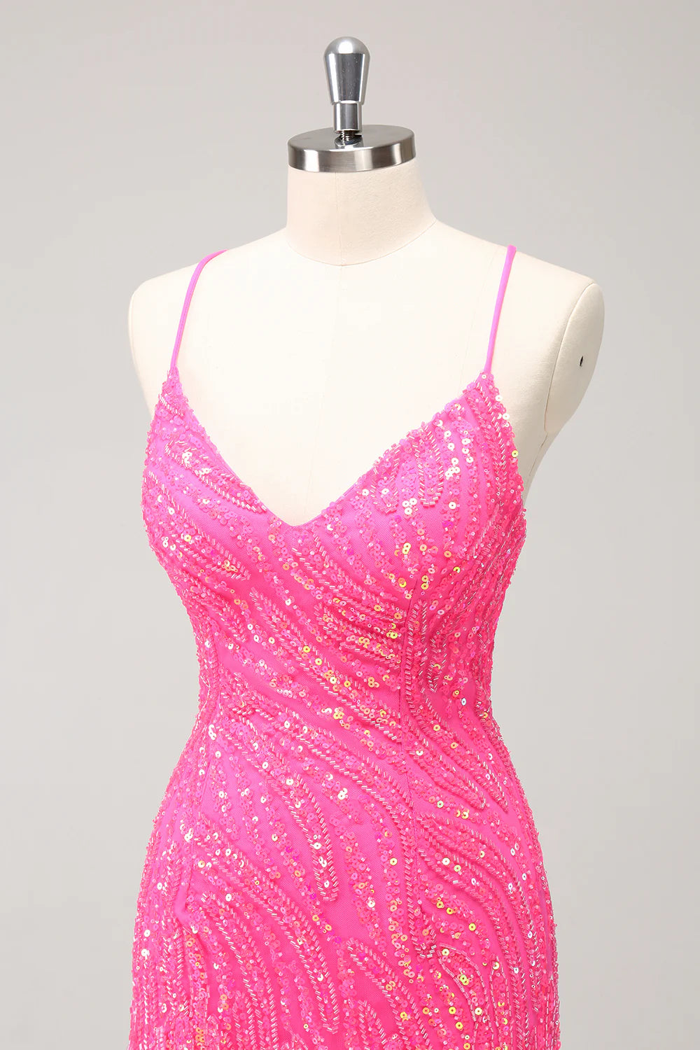 Side view of a hot pink sequin bodycon dress with V-neck and fringes.