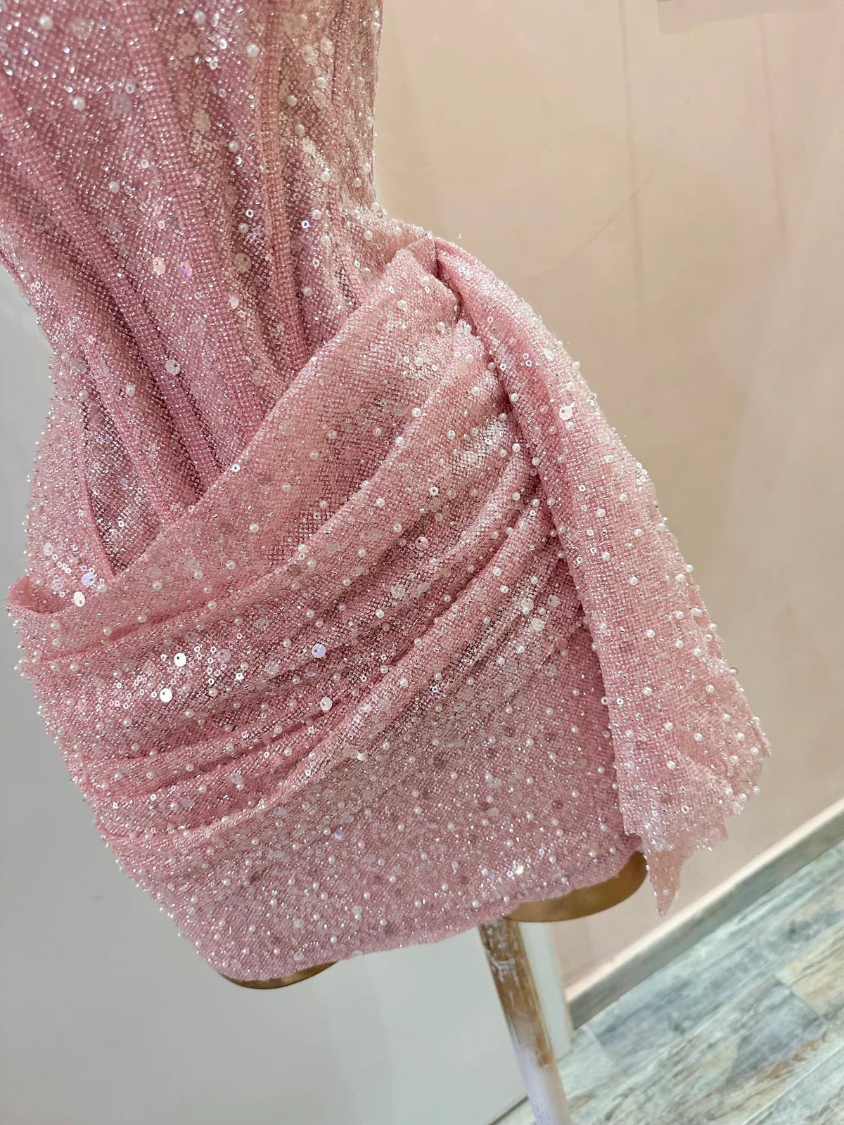 Close-up of the sparkly sequin fabric and corset bodice details on the pink dress.