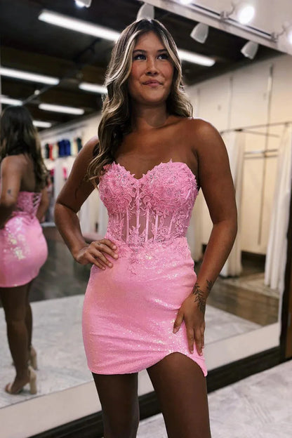 Close-up of the sparkly pink sequin fabric and lace embellishments on the dress.