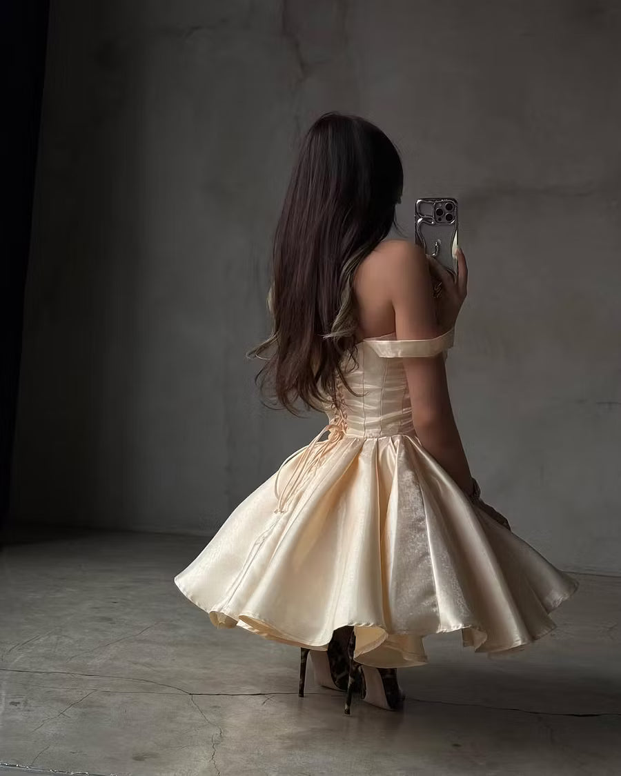 Side view of a model in a champagne A-line off-shoulder dress, showcasing the voluminous skirt.