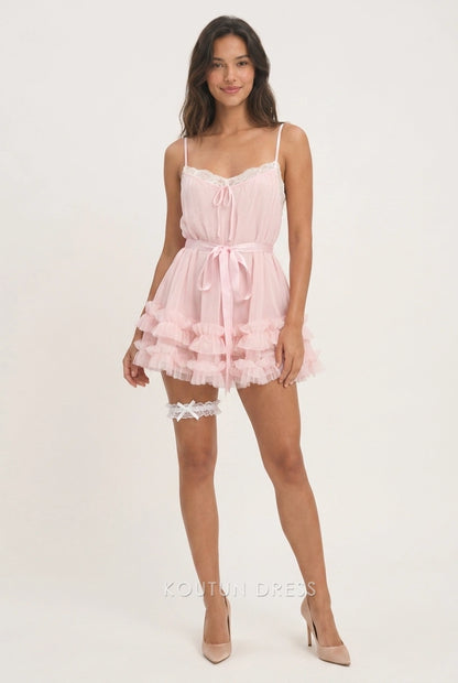 Model wearing a pink A-line mini homecoming dress with lace trim and tiered ruffles.