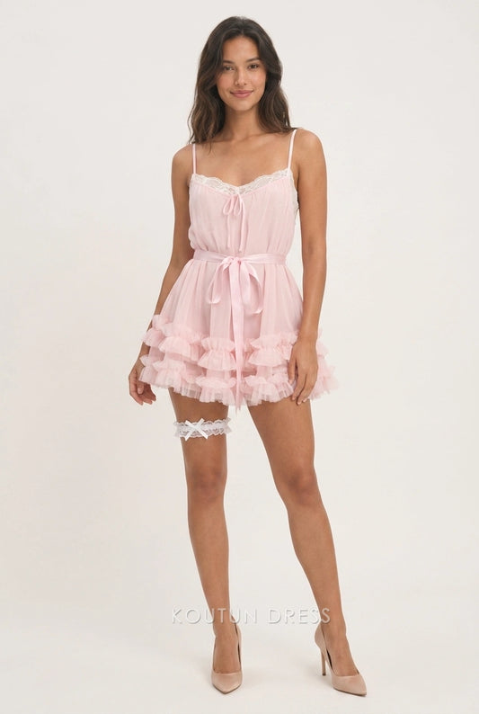 Model wearing a pink A-line mini homecoming dress with lace trim and tiered ruffles.