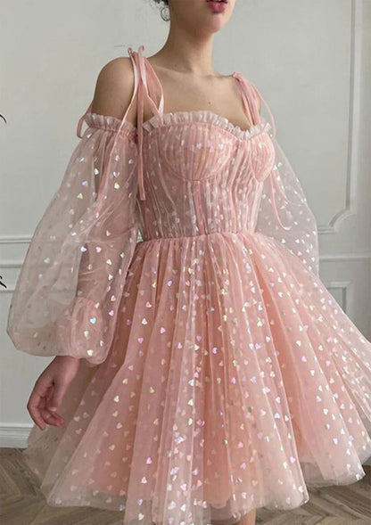 Model wearing a blush pink off-shoulder puff sleeve A-line homecoming dress with heart tulle.