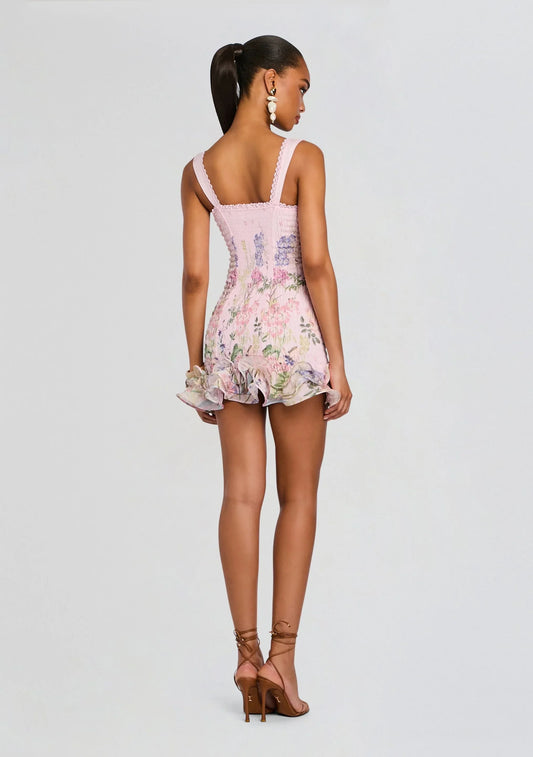Side view of a model in the Koutun pink floral corset mini dress with ruffle hem.