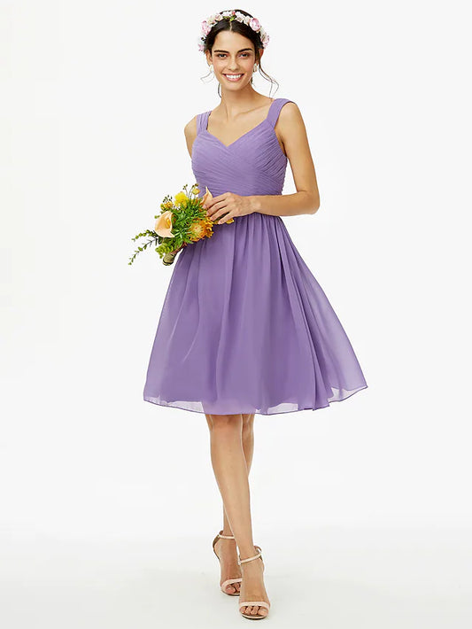 Model wearing an elegant A-line chiffon knee-length bridesmaid dress in blush pink with delicate straps and an open back.