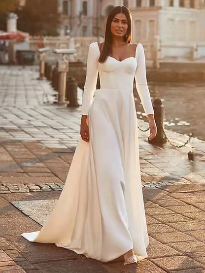 Back view of a woman in a white A-line long sleeve square neck satin wedding dress.