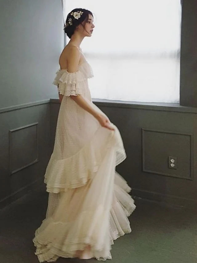 Side profile of a bride wearing an A-Line off-shoulder lace wedding dress.