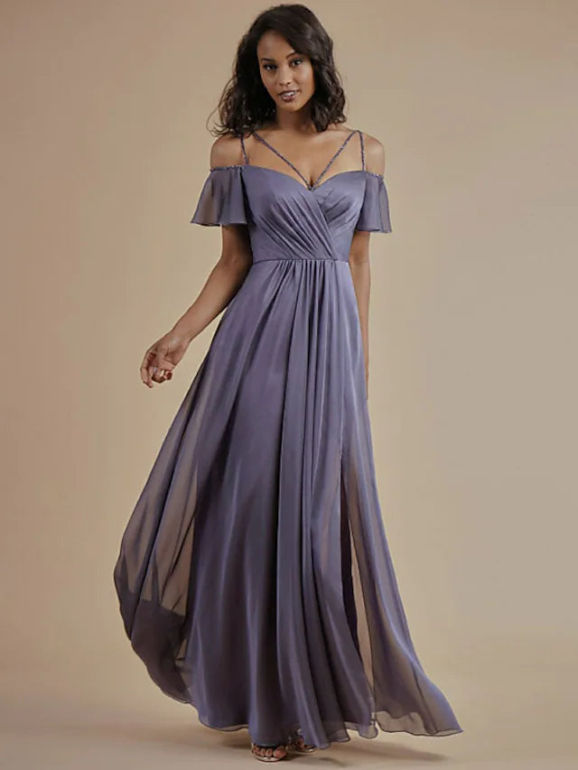 A woman wearing a light blue A-line bridesmaid dress with spaghetti straps, open back, and beading.