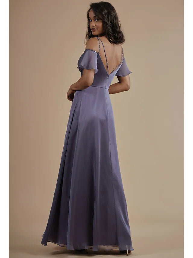 A woman in a light blue A-line chiffon bridesmaid dress, showing the open back and split front details.