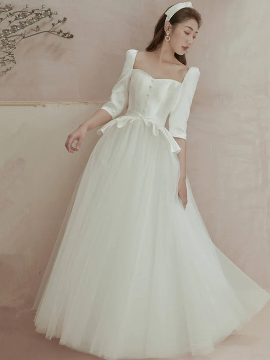 Elegant A-line satin wedding dress with square neck and long sleeves, featuring pleats and ruffles.