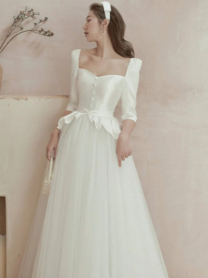 Back view of a floor-length satin wedding gown with delicate ruffles and pleats.