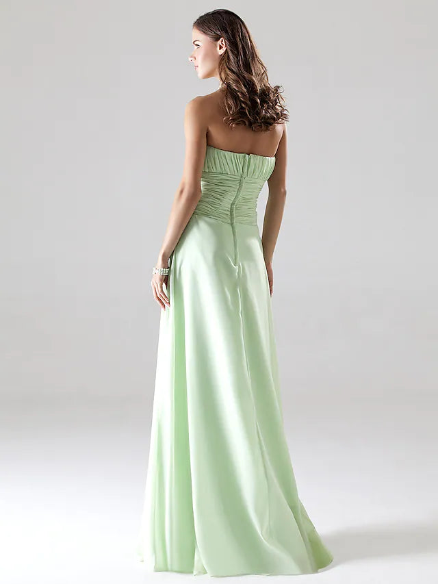 Back view of a woman wearing an elegant strapless A-line chiffon bridesmaid dress with ruched draping.