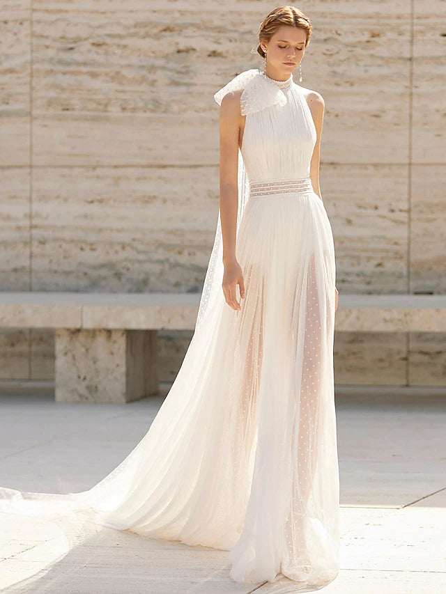 Model wearing a high-neck, sleeveless boho sheath wedding dress with a court train and delicate pattern.