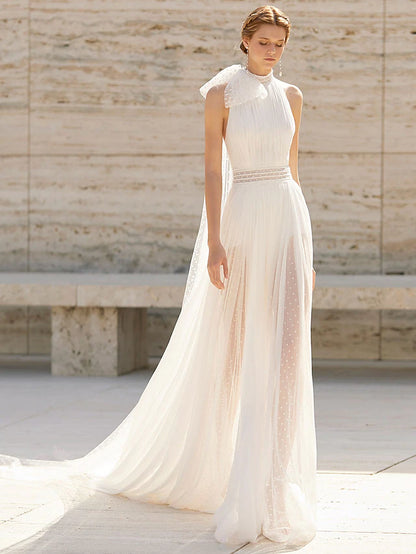 Model wearing a high-neck, sleeveless boho sheath wedding dress with a court train and delicate pattern.