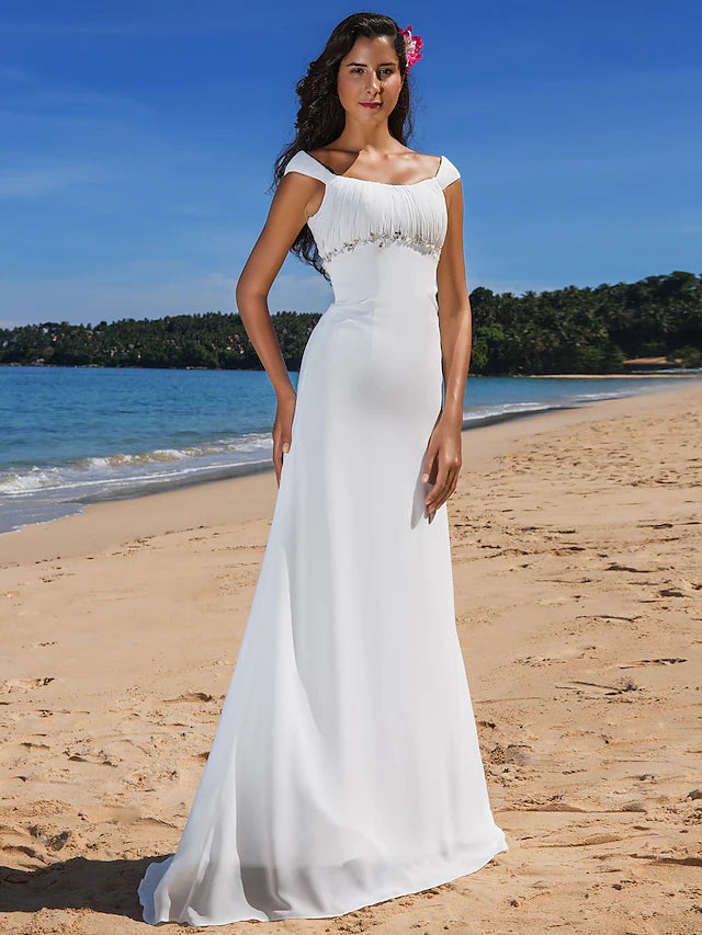 Model wearing a casual chiffon wedding dress with cap sleeves and scoop neck.