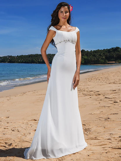 Model wearing a casual chiffon wedding dress with cap sleeves and scoop neck.