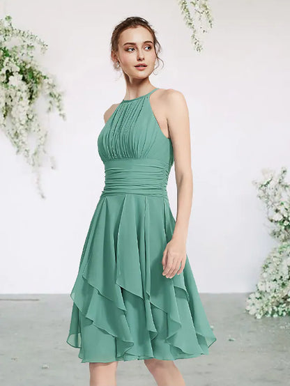 Model wearing an elegant jewel neck sleeveless short mini chiffon bridesmaid dress with pleats and ruffles.