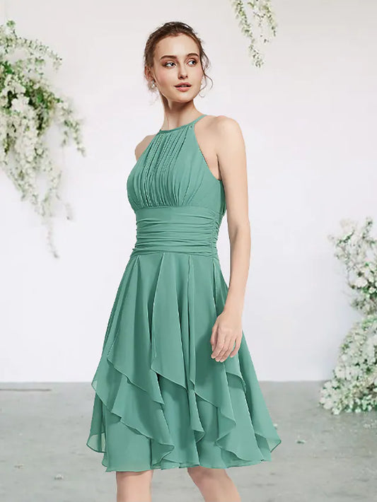 Model wearing an elegant jewel neck sleeveless short mini chiffon bridesmaid dress with pleats and ruffles.