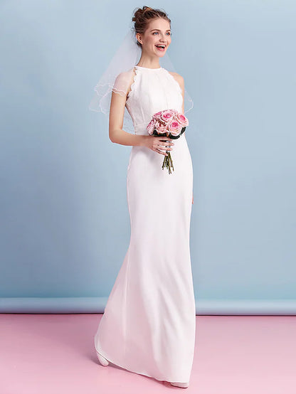 Elegant bride in a floor-length halter neck chiffon wedding dress with lace details.