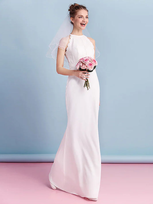 Elegant bride in a floor-length halter neck chiffon wedding dress with lace details.