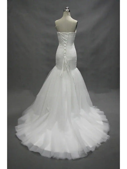 Back view of a white mermaid wedding dress, highlighting the court train and ruched details.
