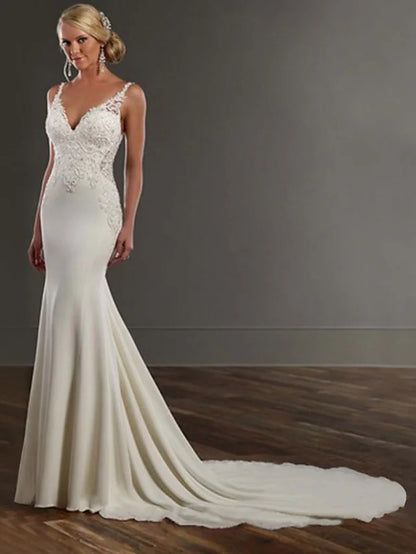 Back view of a white mermaid trumpet wedding dress, showcasing the train and lace details.