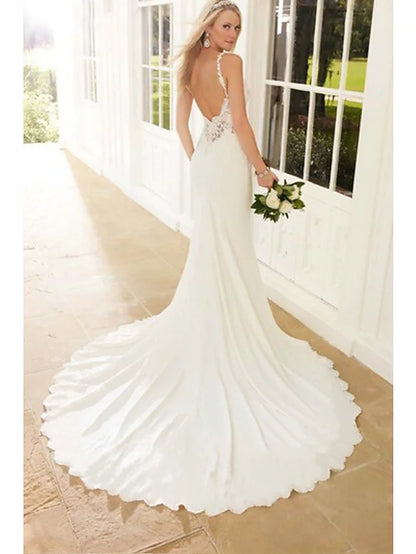 Full length view of a bride posing in a white mermaid trumpet wedding dress.