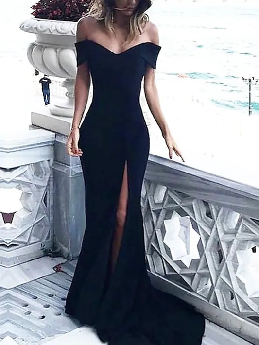 Woman wearing an elegant off-shoulder black formal gown with a high slit and court train.