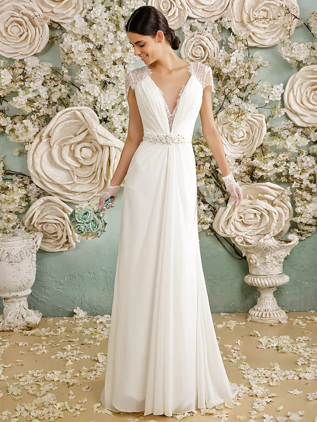 Side view of a bride in a flowing chiffon wedding dress with an open back.