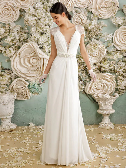 Side view of a bride in a flowing chiffon wedding dress with an open back.