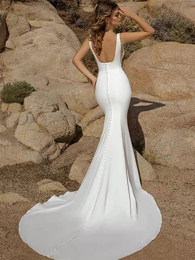 Close-up of the open back and delicate button details on the wedding dress.
