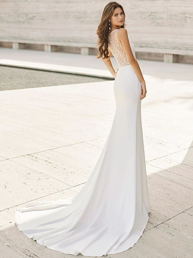 Close-up of the V-neckline and delicate appliques on the satin wedding dress.