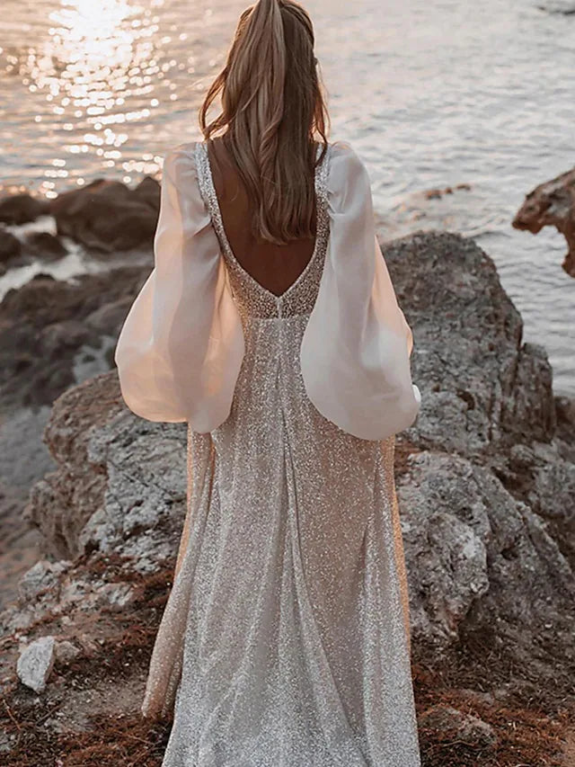 Side view of a sequined and pleated long sleeve bridal gown.
