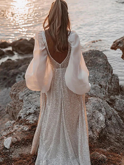 Side view of a sequined and pleated long sleeve bridal gown.