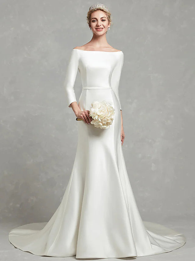 Side view of a bride in a white strapless satin wedding gown, showcasing the pleated detail.