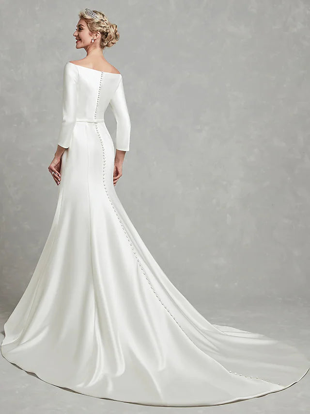 Back view of a white strapless satin wedding dress, highlighting the chapel length train and pleats.