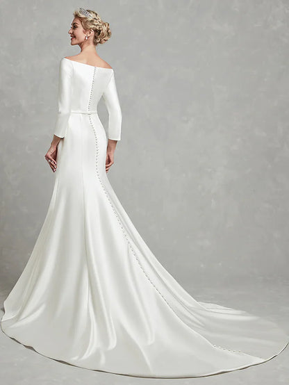 Back view of a white strapless satin wedding dress, highlighting the chapel length train and pleats.