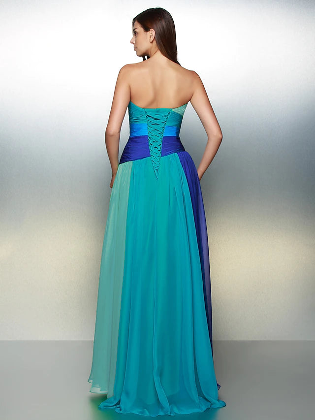 Side view of a woman in a sleeveless floor-length dress with crystal accents.
