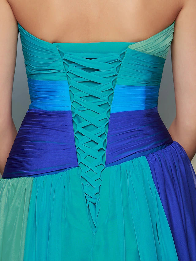 Full view of a woman posing in a formal sweetheart chiffon dress.