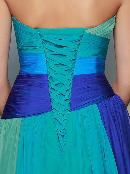 Full view of a woman posing in a formal sweetheart chiffon dress.