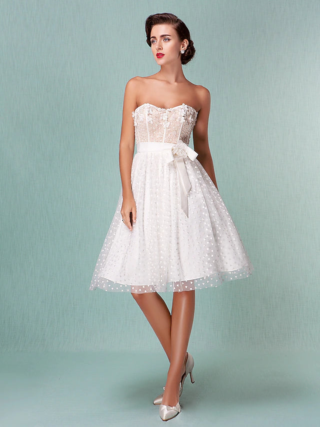 Back view of a strapless sweetheart tulle wedding dress showing the open back and bowknot sash.